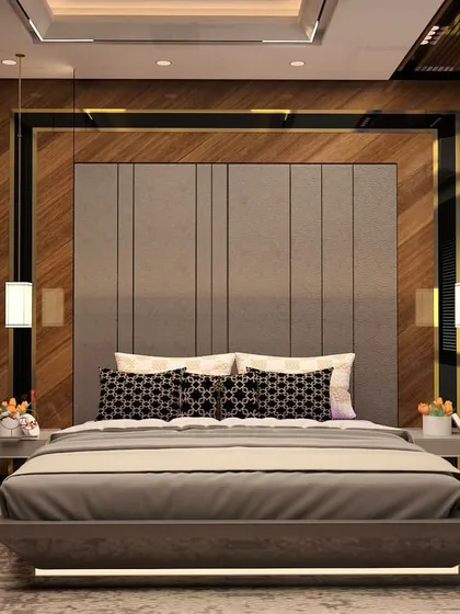 A modern bedroom featuring a grey upholstered headboard set against a backdrop of wood paneling and black accents. The design includes sleek pendant lights and handleless wardrobes for a clean, contemporary finish.