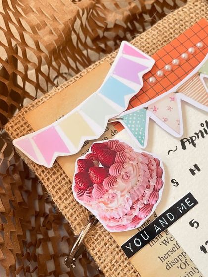 I love the playful details on this scrapbook cover, like the pastel banner and the yummy-looking cake sticker. It’s all about making it fun and personal.