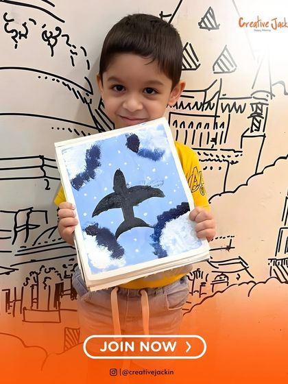 A young boy holds his painting of an airplane flying through a cloudy sky, a creation from one of my imaginative kids' art classes.