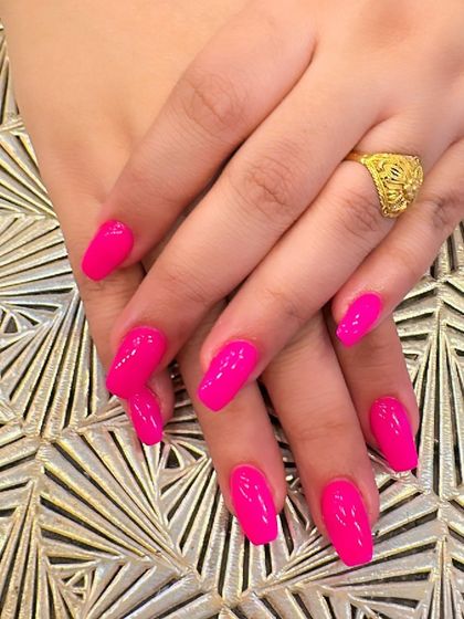 A vibrant and eye-catching set of coffin-shaped nails in a solid, glossy hot pink. This color is perfect for making a bold statement.