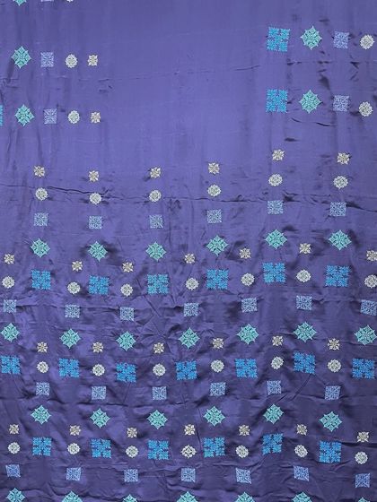 This navy blue pure crepe silk saree is an example of Kasuti in a contemporary style. The geometric motifs are scattered across the fabric in varying shades of blue, creating a modern, elegant look.