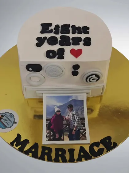 Another version of the Polaroid camera cake, this one celebrating eight years of marriage. It's a fun and nostalgic way to commemorate a special day.