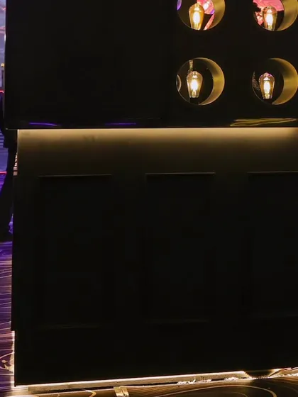 A detail of the sleek, modern bar with under-counter lighting, adding to the sophisticated and moody ambiance.