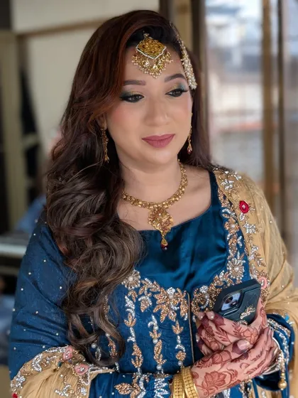 This candid photo captures the elegance of the complete look, from the intricate embroidery on her dress to the detailed henna and full glam makeup.