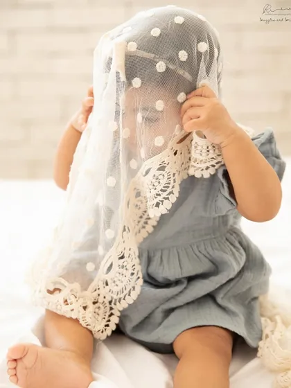 A playful game of peek-a-boo with a lace veil. Sitter sessions are all about capturing their emerging personality and playful spirit.