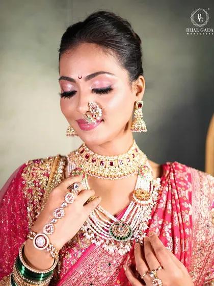 The quintessential Maharashtrian bridal look, featuring a crescent moon 'bindi', a traditional 'nath', and soft pink makeup that beautifully complements the pink Paithani saree.