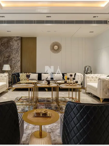 This formal living room is designed for sophisticated entertaining. We paired classic tufted sofas in white with modern quilted black armchairs, creating a chic black-and-white theme with gold accents for a touch of glamour.