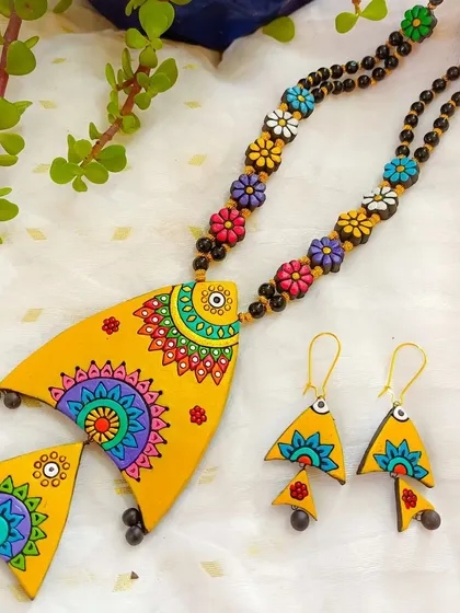 This is my beautiful fish-themed necklace, with a large yellow fish pendant decorated with multi-color mandala art. The chain is made of colorful flowers, adding to its playful charm.