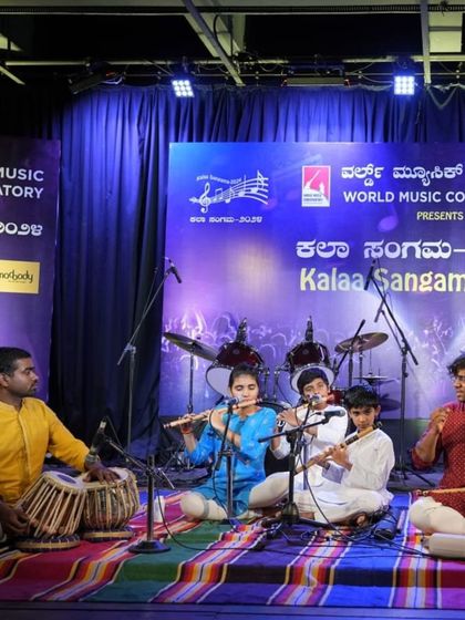The full bansuri ensemble on stage, including students on flute and their guru on tabla, creating a complete musical picture.