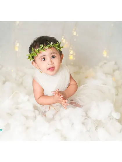 A sweet and innocent expression from our little angel, complete with a delicate floral crown.