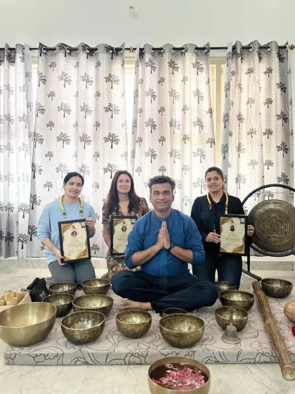 The graduates of a sound healing course pose with their certificates, a symbol of their dedication and new skills.