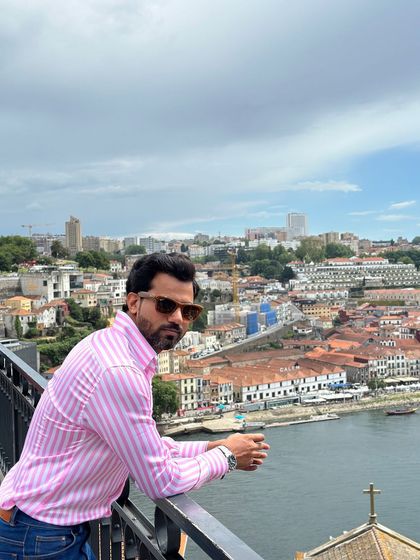 Overlooking a scenic cityscape, the candy stripe shirt adds a pop of color and personality to this travel look.