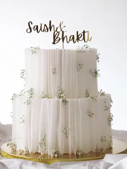 This two-tier Nutella Hazelnut cake is all about clean lines and delicate details. I used edible wafer paper to create a soft, draped fabric effect, dotted with tiny sprigs of baby's breath for a touch of minimalist elegance.