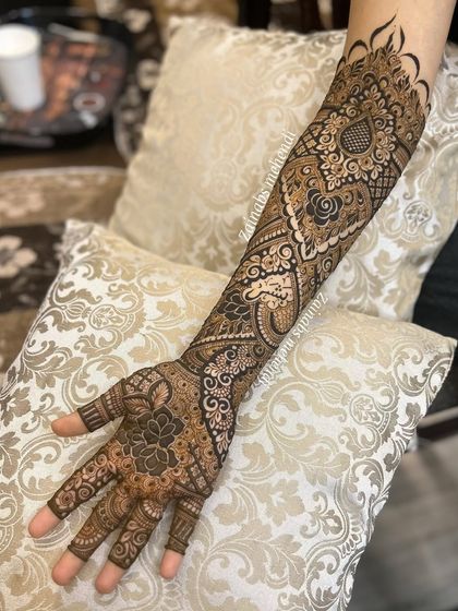 A complete view of Afreen's bridal arm, showcasing the beautiful paisley and floral patterns.