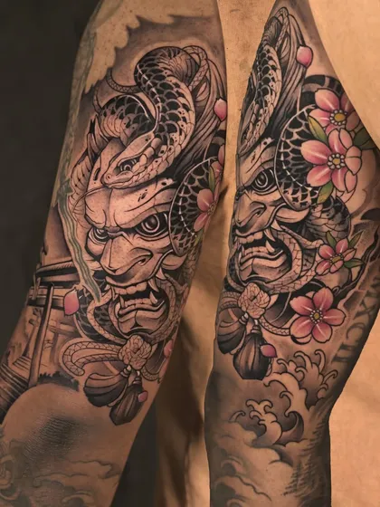 A powerful Japanese sleeve featuring an Oni mask, snake, and sakura blossoms. This piece, which is the same as our hero image, was an 18-hour project for a dedicated client.