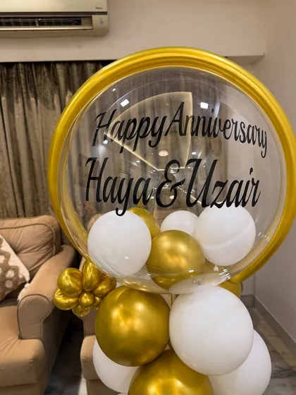 Our sit-down balloon arrangements are perfect for anniversaries. This one features a personalized message for the couple, surrounded by elegant white and gold balloons.