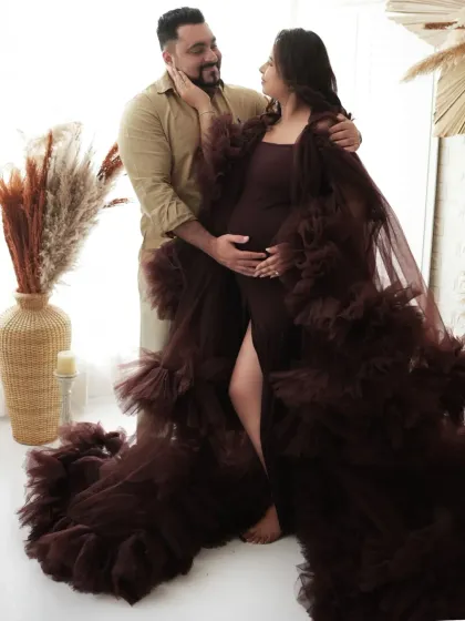 Capturing the loving connection between partners. This intimate pose, combined with the dramatic brown gown, makes for a beautiful and emotional maternity photograph.