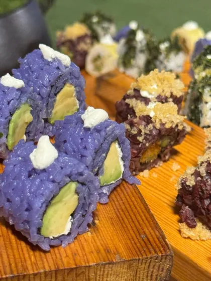 A colourful array of our creative sushi rolls, including avocado-filled purple rice sushi. We love to play with colours and ingredients to make our Japanese offerings visually stunning.