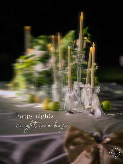 A hazy, romantic shot of the candlelit tablescape, capturing the magical atmosphere of the seaside dinner.