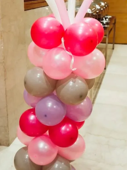 A close-up of a balloon pillar in shades of pink, purple, and grey. We use a mix of colors and sizes to create visually interesting and beautiful balloon art for any theme.