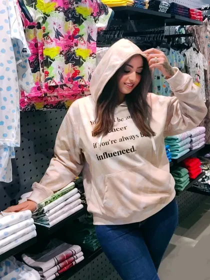 A customer wearing a custom printed hoodie with the quote, "How can you be an influencer if you're always being influenced."