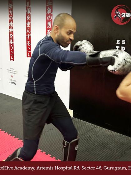 A student practices his boxing combinations on the pads, showing the intensity and focus that defines our training sessions. We help you strike harder and move faster.