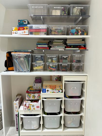 A full view of a child's supply closet. We use a combination of clear and opaque bins to store books, art supplies, and toys, creating a system that can grow with the child.