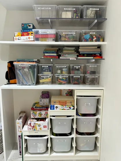 A full view of a child's supply closet. We use a combination of clear and opaque bins to store books, art supplies, and toys, creating a system that can grow with the child.