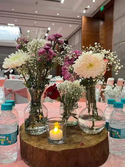 A rustic centerpiece featuring a collection of small vases on a wooden log slice, perfect for a more natural and organic theme.