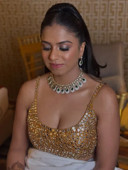 A close-up of another sangeet look, featuring a stunning mirror-work blouse and smokey eye makeup.