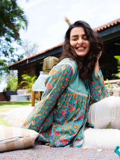 A candid, joyful moment captured in a sunny, outdoor setting. The model's genuine smile and relaxed posture create a lifestyle image that feels warm, natural, and full of life.