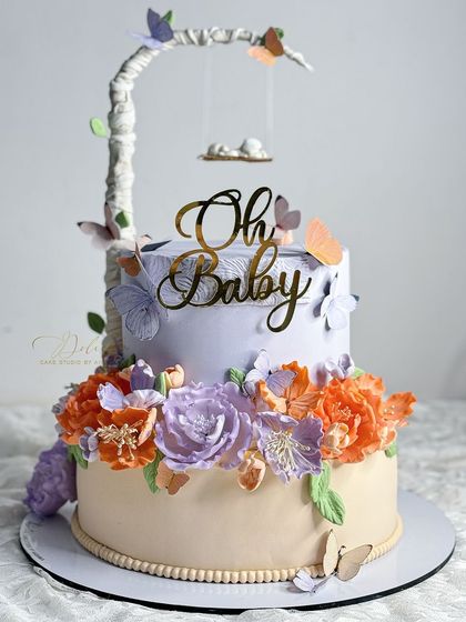 For a "Baby in Bloom" themed shower, we created this unique swing cake with a tree-branch structure and a cascade of handmade sugar flowers in bright, beautiful colors.