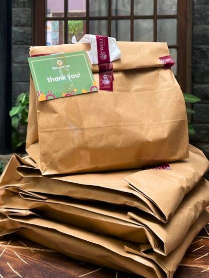 Home-style meals delivered straight to your office or home. A stack of freshly packed orders, each with a 'thank you' note, ready to bring a taste of home to you.