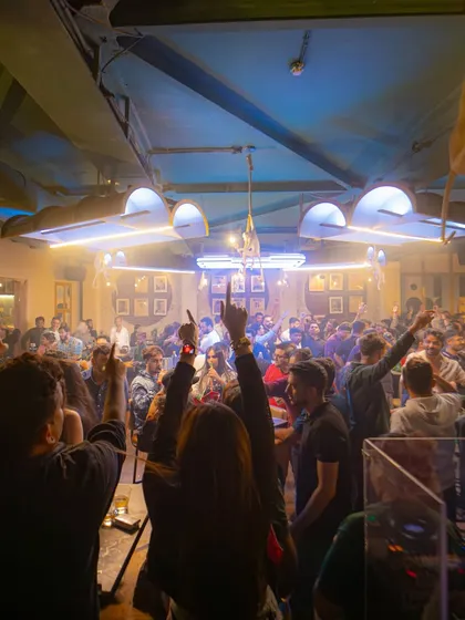 The crowd at Badmaash Company with their hands up, united by the beat.