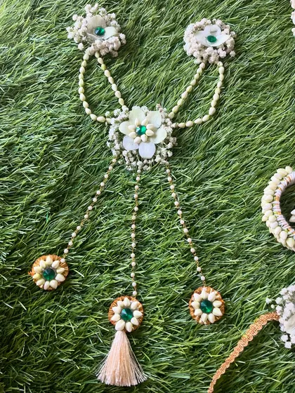 This unique piece is a 'hath-paan' style of haath phool, with floral chains that connect the bracelet to all five finger rings. This was made for a baby shower.