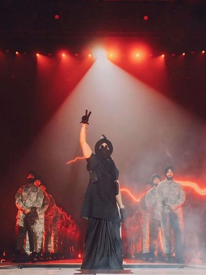 Diljit Dosanjh commands the stage under a single spotlight. A dramatic and powerful shot from his live concert, capturing his iconic performance style.