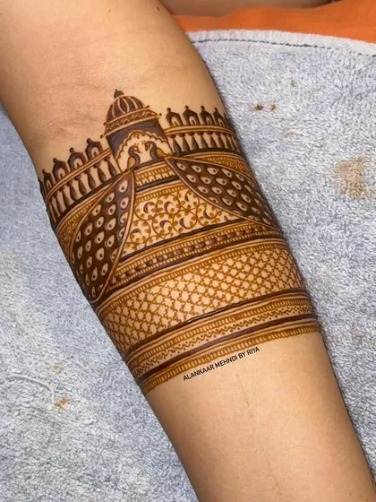 A bridal arm band featuring two peacocks with their feathers creating a beautiful pattern, set against a palace backdrop.