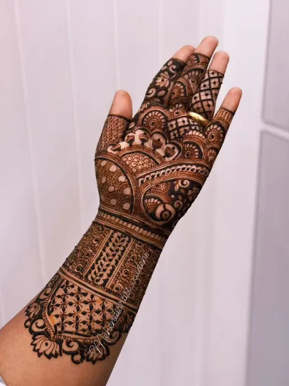 The back of the hand for the previous design. The patterns are consistent, with a beautiful cuff-like design on the wrist and delicate work extending towards the fingers.