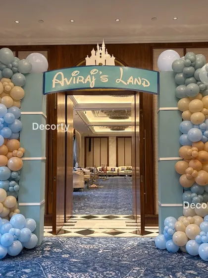 The grand entrance to "Aviraj's Land," framed by columns and beautiful balloon arches in pastel blue and peach, setting a magical tone from the moment guests arrive.
