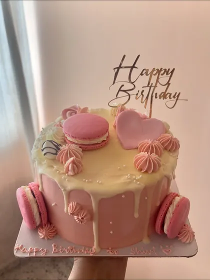 A closer look at one of my custom birthday cakes. This one features a rich chocolate sponge with a 55% dark chocolate ganache, finished with a smooth vanilla buttercream, white chocolate drip, and delicate pink macarons for a special touch.