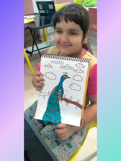 This young artist proudly displays her beautiful peacock drawing. Our drawing classes encourage kids to observe nature and express its beauty through their own colorful creations.