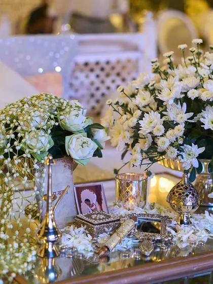 A beautiful arrangement featuring a 'gajra' of baby's breath, draped over a vase. This is a modern take on a very traditional floral element.