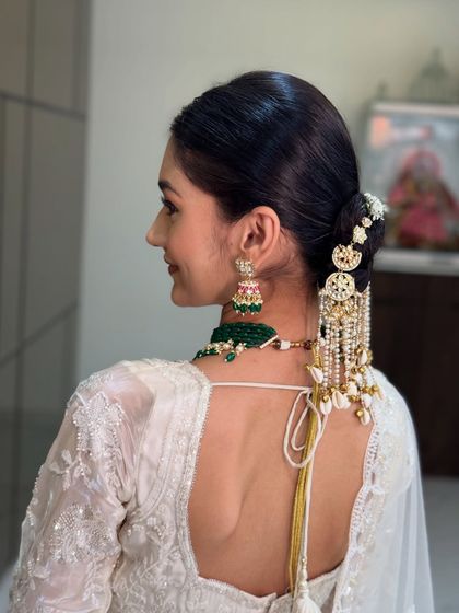 A view of the elegant low bun from the back, adorned with statement hair accessories. This hairstyle is perfect for a sophisticated and modern bridal look.