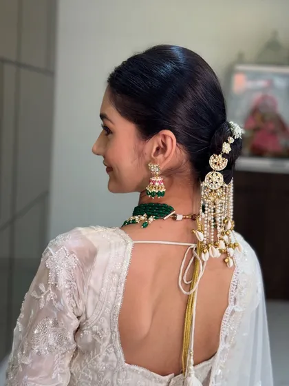 A view of the elegant low bun from the back, adorned with statement hair accessories. This hairstyle is perfect for a sophisticated and modern bridal look.