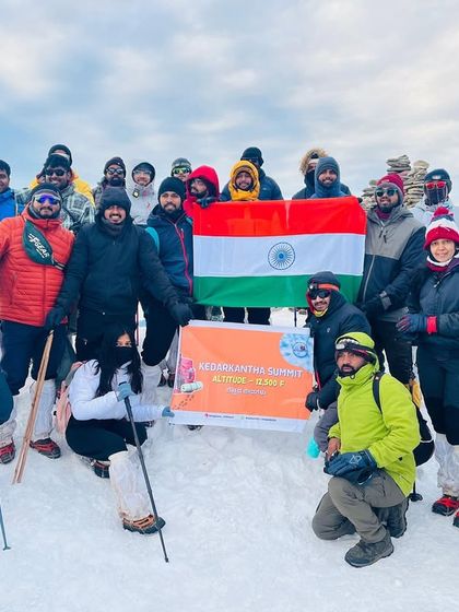 The entire group celebrating at the Kedarkantha summit, a testament to their hard work and perseverance. A proud moment for everyone.