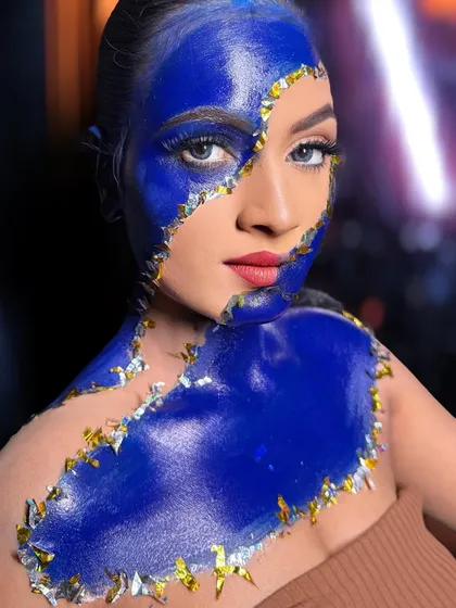 A broken-galaxy inspired look. This abstract, creative makeup uses bold color and gold foil to create a stunning visual effect.