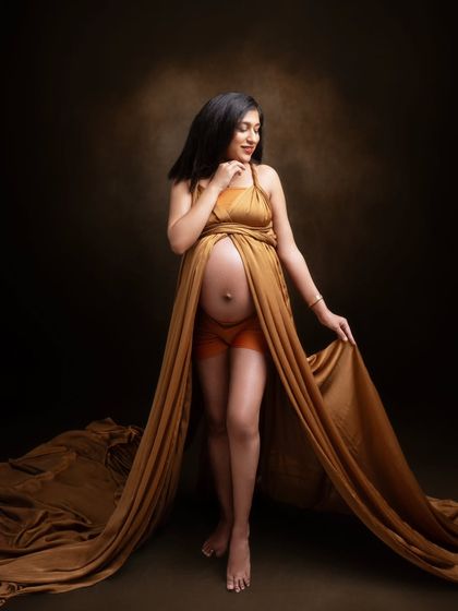 A goddess in her own right. This portrait captures her silhouette, strength, and story, styled with a beautiful golden fabric drape.