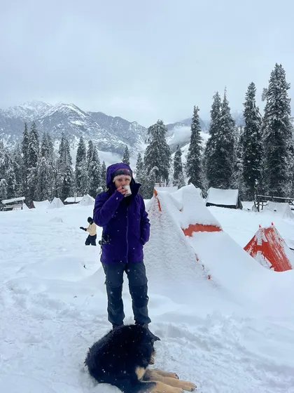 Snow, hot tea, and a furry friend. This is heaven on earth at the Kedarkantha campsite.