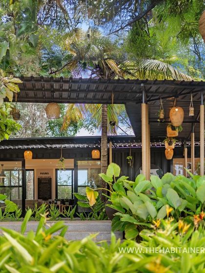 Surrounded by tropical foliage, this container office feels like a tranquil oasis. The design uses dark-colored containers and natural wood elements to blend seamlessly into the verdant landscape.