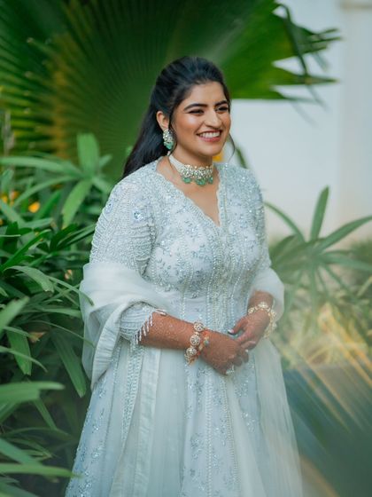 The bride's Sangeet look was all about elegance and comfort. The ivory zardozi jacket paired with an organza skirt and emerald jewelry created a look that was both regal and easy to wear.